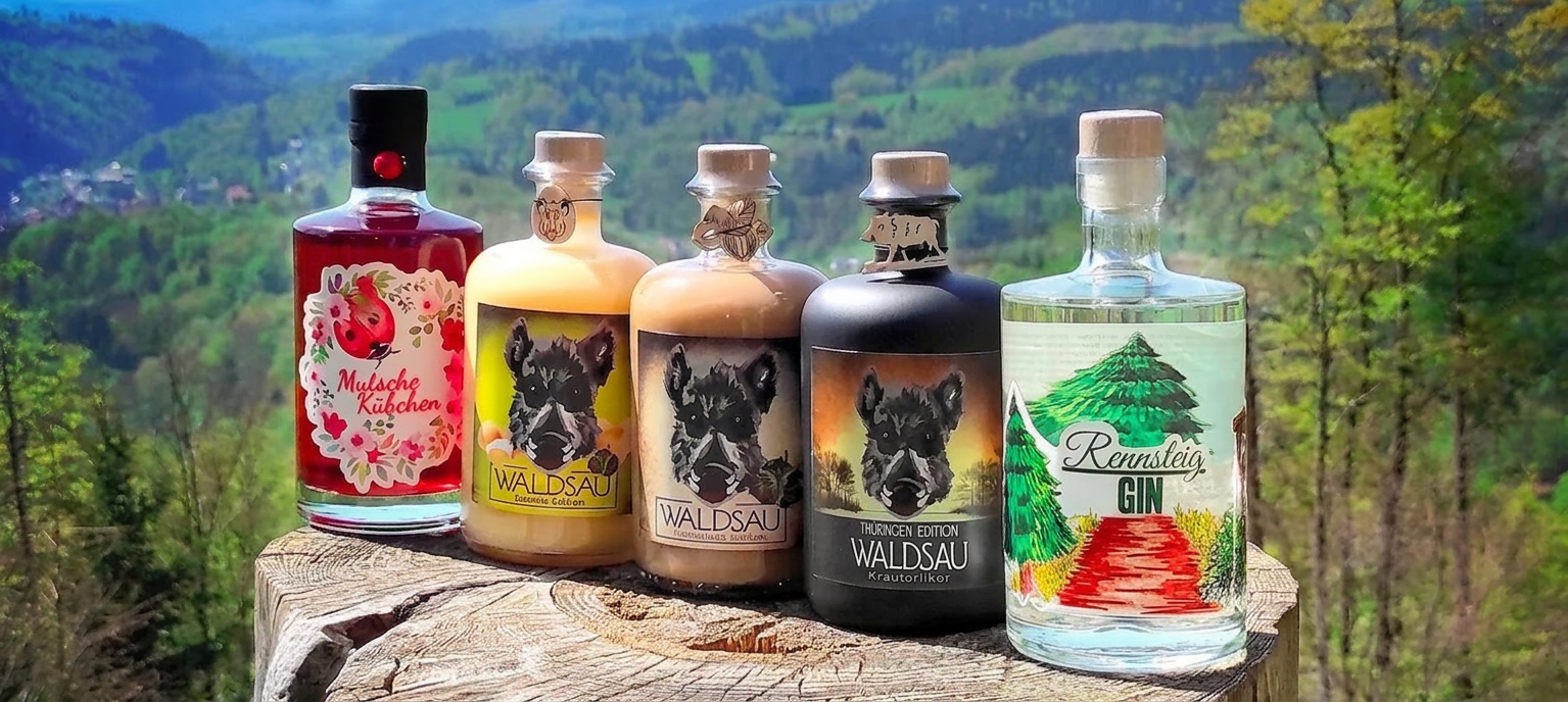 Rennsteig Liköre und Gin auf einem Baumstamm im Thüringer Wald